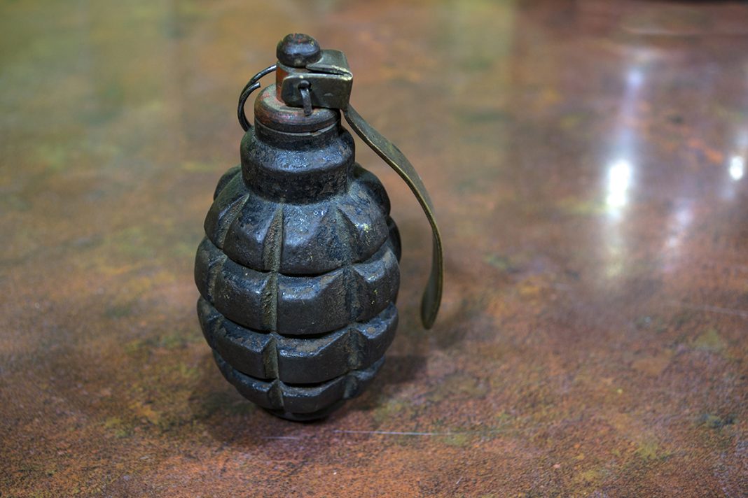 Fragmentation grenade with hole, on camouflage clothing